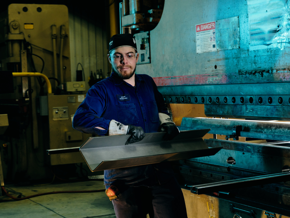 A QuadMetalworks employee operating a press brake