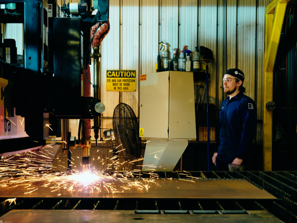QuadMetalworks employee operating a plasma lazer for sheet metal