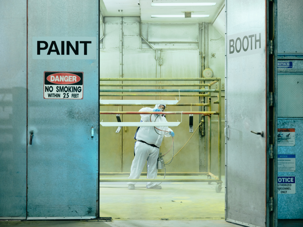 A QuadMetalworks employee painting custom fabricated equipment for a client